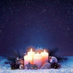 Four burning advent candles on white snow isolated.
