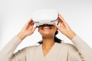 Smiling african american woman using virtual reality headset isolated on white.