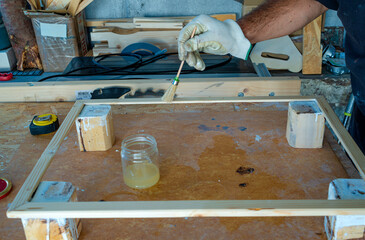 Focused mid adult hobbyist varnish a wooden board with protective oil