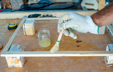 Focused mid adult hobbyist varnish a wooden board with protective oil