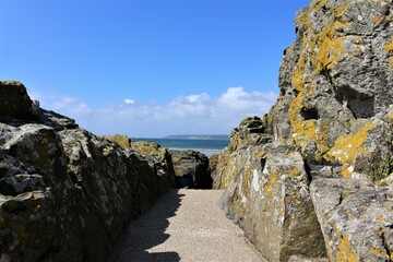 Path between cliff rocks with blue skies