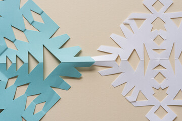 two paper snowflakes on ivory