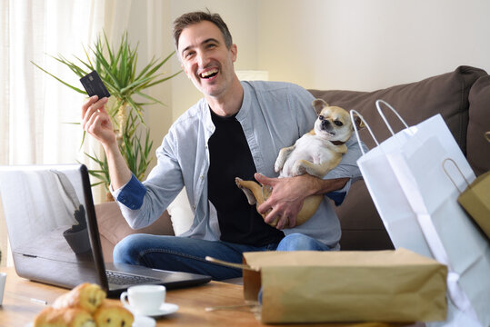 Cheerful Man Doing Online Shopping With His Dog At Home