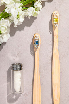 Studio shot of wooden toothbrushes, biodegradable dental floss and blooming flowers