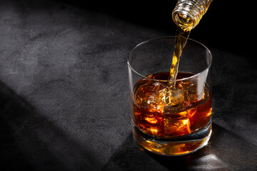 Pouring whiskey into the glass.