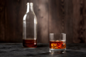 Whiskey bottle and whiskey glass with ice.