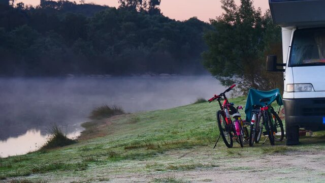 Caravan family vacation. Fog over lake in morning and camper camping on shore. Povoa e Meadas Dam in Castelo de Vide, Alentejo Portugal.