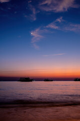 Fototapeta na wymiar Twilight and crescent moon by the sea in Pattaya Bay