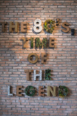 Eco cafe design in brown colours. Decorative inscription on a brick wall. The 80's, time of the legends. Coffee shop interior. High quality photo