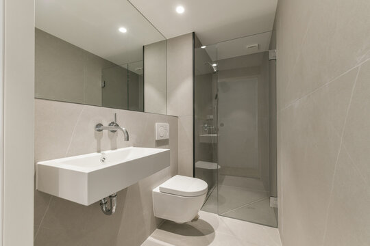 Interior of bathroom with ceramic sink and toilet bowl