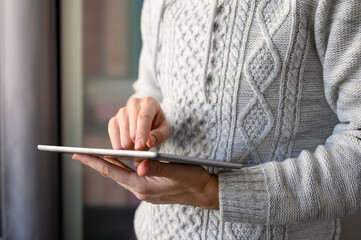 Close-up of a man uses a tablet. Selective focus on the index finger.