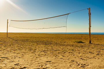 Volleyball net on sandy beach.