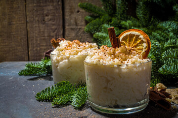 Risgrynsgrot, scandinavian-style Christmas rice porridge with cinnamon and spices, with Christmas tree branches decor 
