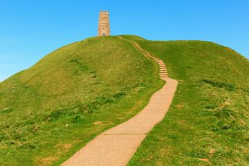 Glastonbury tower Somerset historic tor landmark and tourist attraction with hill and path England...