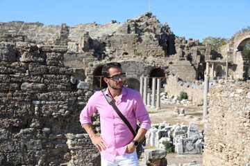 Mężczyzna na wakacjach podczas zwiedzania starożytnych ruin.  - obrazy, fototapety, plakaty