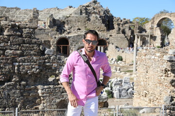 Mężczyzna na wakacjach podczas zwiedzania starożytnych ruin.  - obrazy, fototapety, plakaty