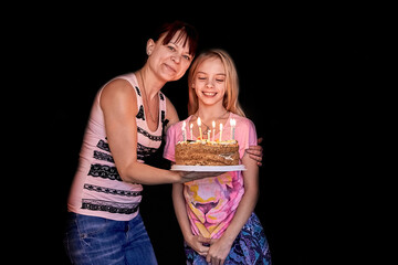 The happiest family.Mom gives her cute daughter a birthday cake