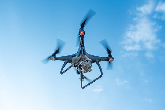 Modern dark drone in the blue sky.