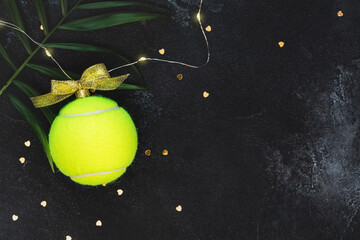 Tennis, winter holidays composition with yellow tennis ball in the form of a New Year's ball, palm...