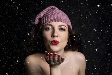 Bella donna nuda con cappello invernale sotto la neve