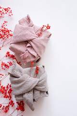 Gift boxes in natural fabric on white background with red dry flowers. Eco and sustainable gift wrapping ideas. Festive backdrop with Furoshiki wrap. Recycling and eco-friendly alternatives.