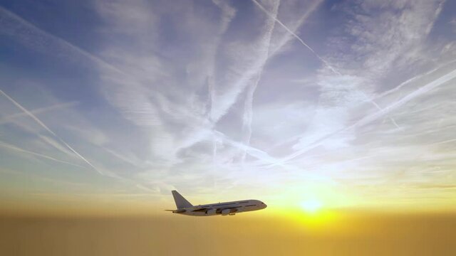 An unbranded commercial airplane flying at altitude in front of a golden sunset with airplane contrails across the sky.