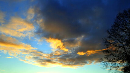 Obraz premium golden leuchtende Wolken am dunklen Abendhimmel während des Sonnenuntergangs im Schwarzwald