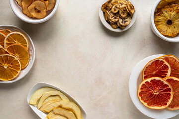 Obraz na płótnie Canvas Homemade organic dried fruit slices in plates, top view. Dried orange, grapefruit, pineapples, copy space