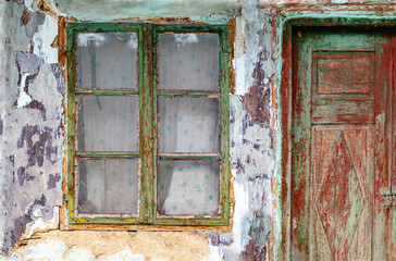 Exterior of an old cracked wall with old window and doors
