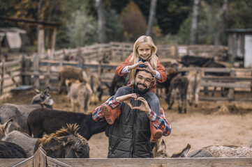 Farmer holding his daughter on shoulders and feeling good