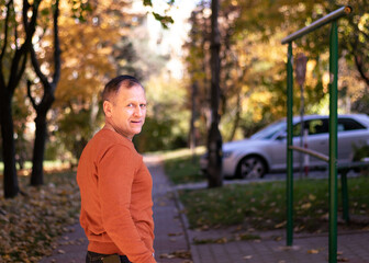 mature handsome man, middle age, 50-60 years old, walking in autumn park