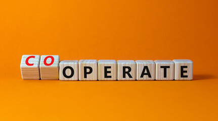 Operate and cooperate symbol. Businessman turns wooden cubes and changes the word operate to cooperate. Beautiful orange table, orange background. Operate, cooperate and business concept. Copy space.