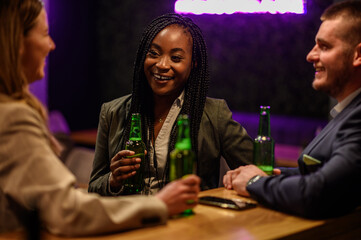 Cheerful colleagues drinking beer in the bar together after work