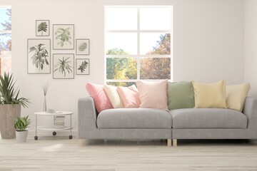 Fototapeta premium Stylish room in white color with sofa and autumn landscape in window. Scandinavian interior design. 3D illustration