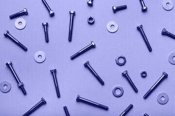 Bolts and nuts closeup on lilac background.