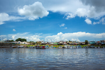 Fototapeta na wymiar Beautiful view of Amazon River and Itacoatiara city skyline in summer sunny day with clouds. Manaus, Amazonas, Brazil. Concept of environment, ecology, nature, cityscape, travel, architecture.