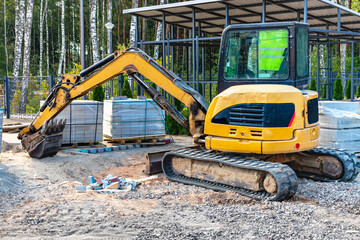 Mini excavator at the construction site. Compact construction equipment for earthworks.