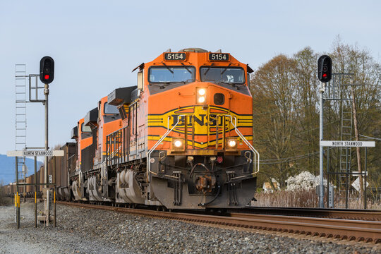 Stanwood, WA, USA - April 06, 2021;  BNSF 5154 passing North Stanwood Southbound with four headlights shining forming a part of the North American supply chain