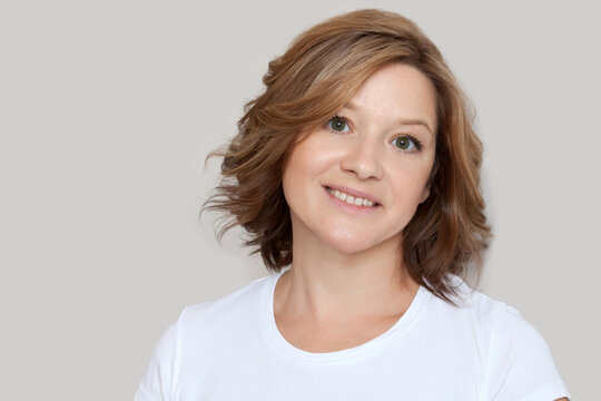 Smiling middle aged 40 years old woman. Portrait of a mature woman looking at the camera against a light background. Natural beauty.