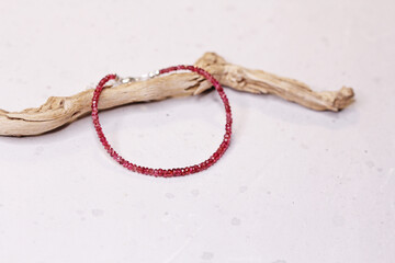 Ruby silver bracelet. Bracelet made of stones on hand from natural stone ruby. Bracelet made of natural stones. Handmade jewelry. Handmade bracelets on light modern background. Thin bracelet