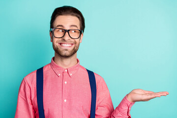 Photo of young dreamy happy man look empty space hold hand excited object isolated on teal color background