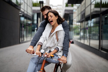 Beautiful happy couple in love on bicycle in the city