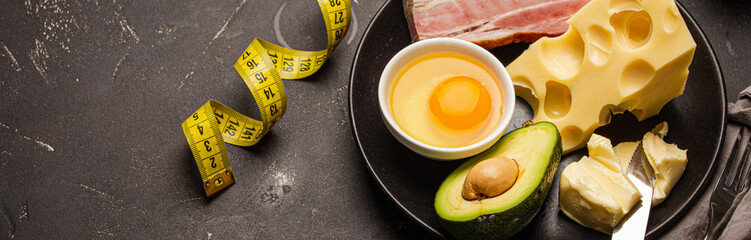 Keto foods as butter, olive oil, fried egg, avocado, fat meat bacon, cheese for ketogenic diet on...