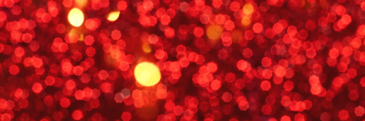 Red and golden sparkling glitter bokeh background, christmas texture. Holiday lights. Abstract defocused header. Wide screen wallpaper. Panoramic web banner with copy space for design