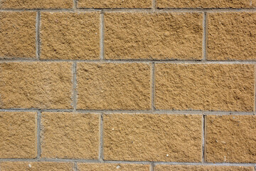 Beige wall tiles imitating brickwork. Modern finishing material. Gray facade facing tiles, imitating a brick. Background texture. Exterior facade decoration close-up