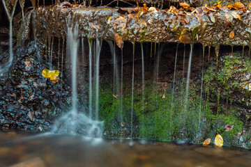 Tranquil waterfall scenery in the middle of autumn forest