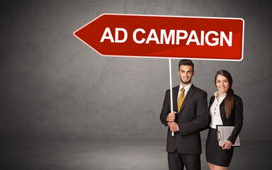 Young business person in casual holding road sign