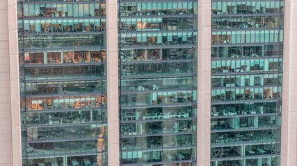 Fototapeta na wymiar Big glowing windows in modern office and residential buildings day to night timelapse