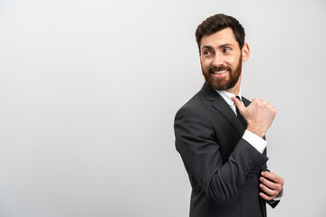 Like. Portrait of optimistic handsome brunette man with beard showing thumb up gesture and smiling, meaning well done, good job. Indoor studio shot isolated on white background