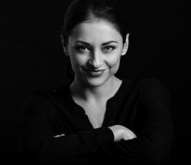 Beautiful confident happy smiling business woman with folded arms on black background with empty copy space. Closeup portrait